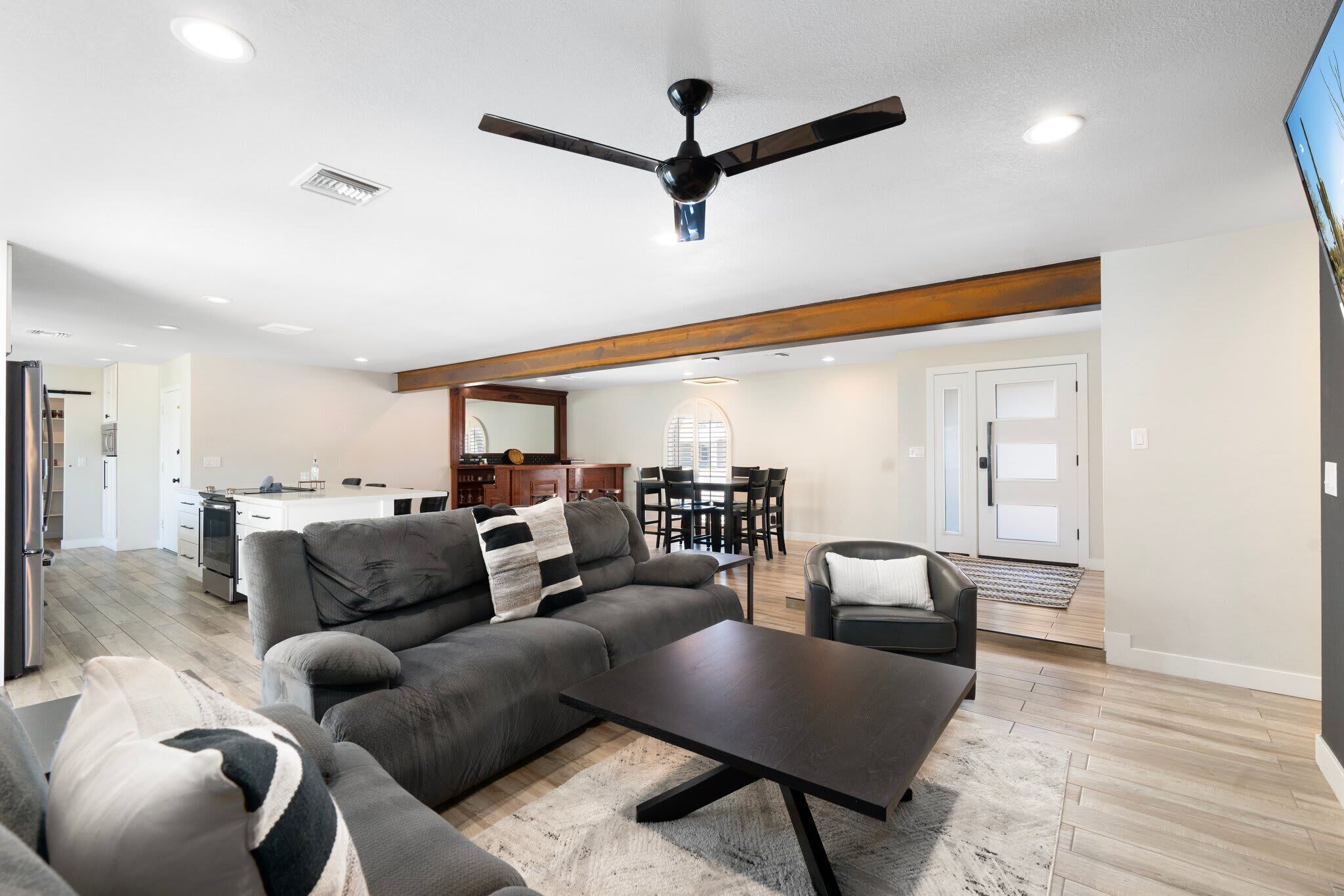 A modern living room with a sofa, coffee table, and a ceiling fan.