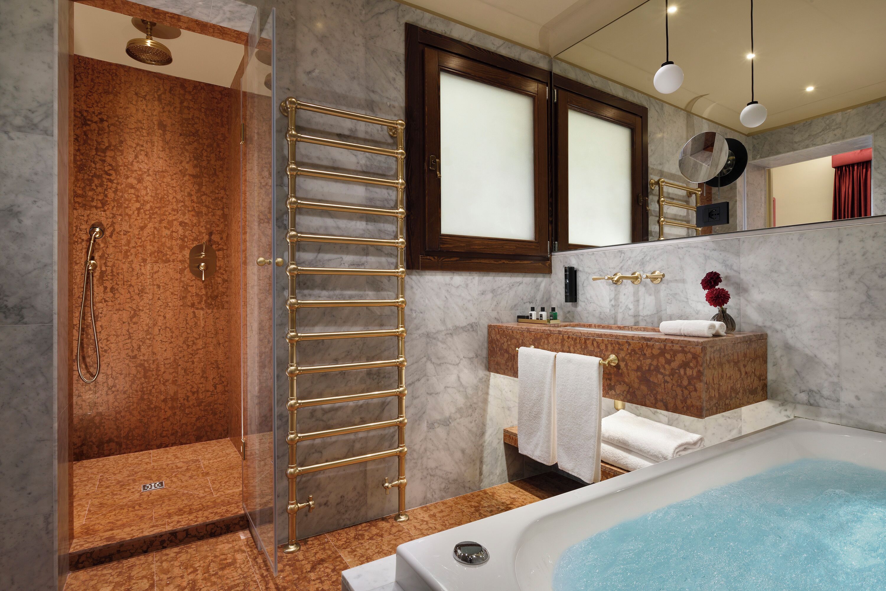 Un bagno moderno con doccia vetrata, una vasca freestanding e un mobile lavabo con specchio.