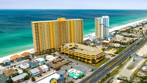 A coastal cityscape with high-rise hotels, a beach, and a road.
