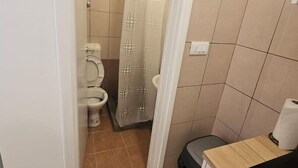 Uma casa de banho pequena com sanita, bidé e cortina de chuveiro.