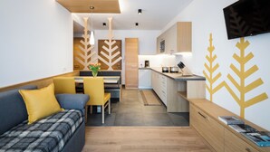A modern living room with a sofa, a dining area, and a kitchen. - Fantastic vacation in the Dolomites (St. Martin in Thurn)