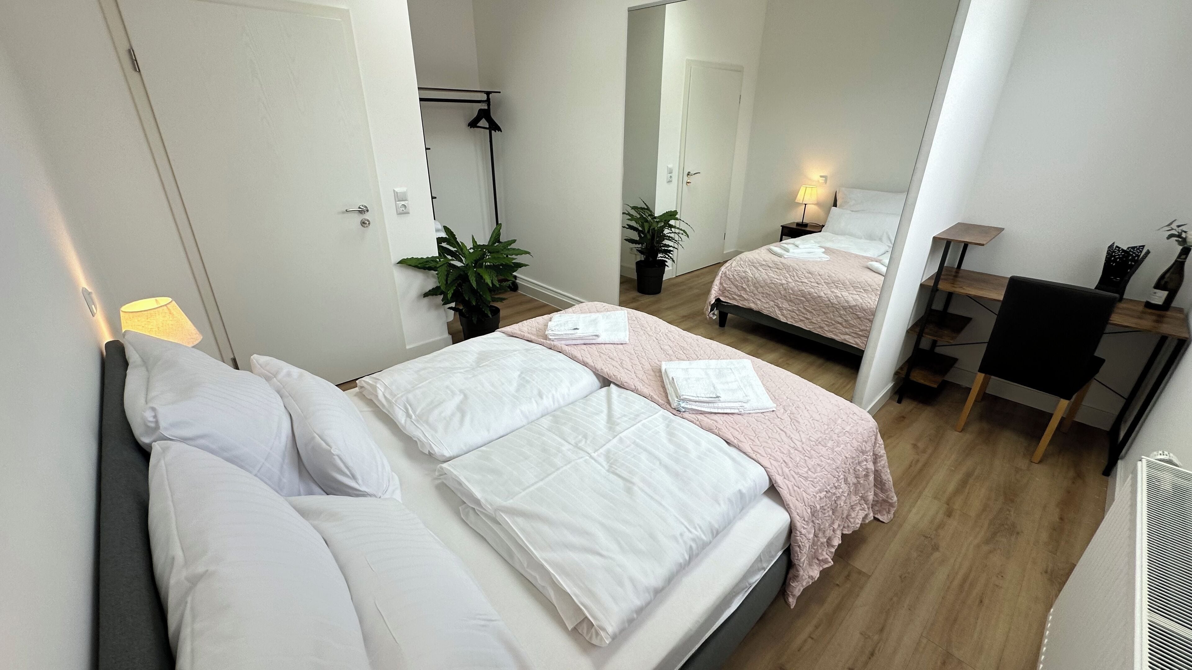 Une chambre d’hôtel moderne équipée de deux lits, d’un bureau et d’une chaise.
