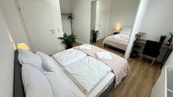 Une chambre d’hôtel moderne équipée de deux lits, d’un bureau et d’une chaise.