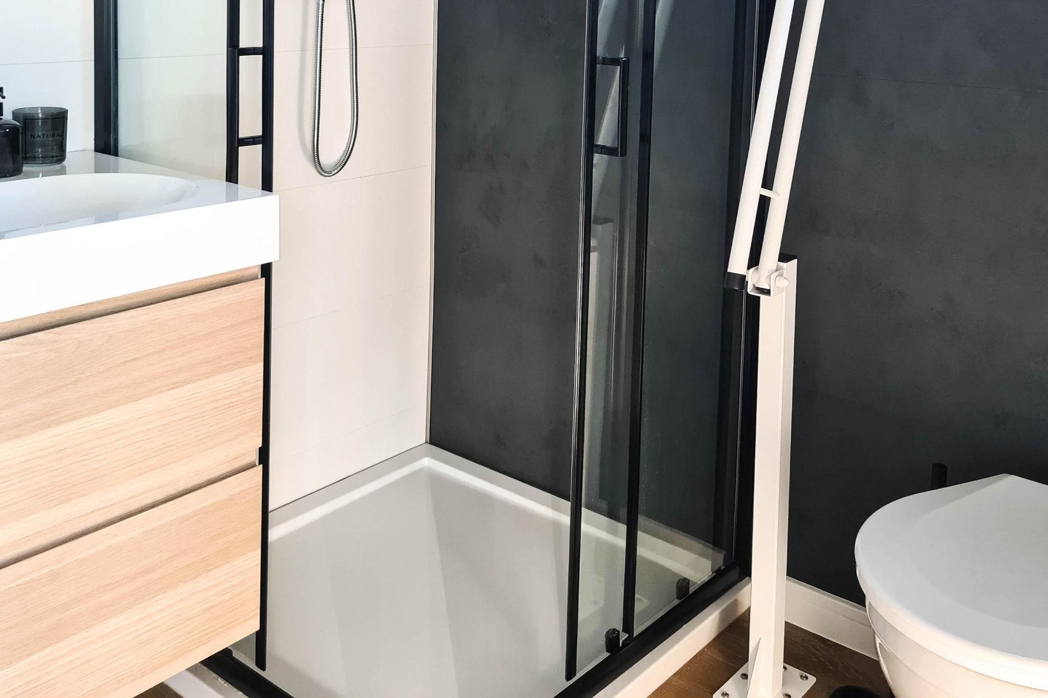 Un baño moderno con cabina de ducha, inodoro y zona de lavamanos.