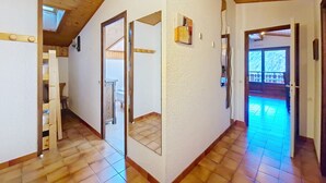 A spacious hallway with wooden flooring, a sloped ceiling, and a view of an outdoor area. - Alpenlake AP139 VIEW & NATURE  6 Pers. (Châtel)