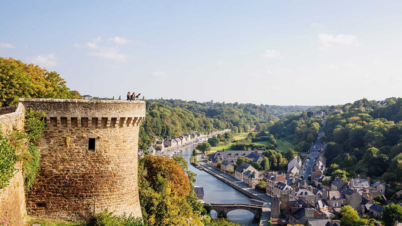 A stone tower with a river and town in the background.