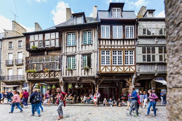 A traditional European street with half-timbered buildings and outdoor seating areas. - Grande Maison de Vacances et WE Près de Dinan (Trévron)