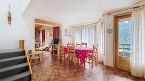 A dining area with a wooden table and chairs, a staircase, and a view of the outdoors. - VAL PIERRE VPD2 CENTER & SPACIOUS 8 Pers. (Châtel)