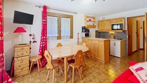 A compact kitchen with wooden cabinets, a microwave, and a small refrigerator. - Gelinote GL3 TELECABINE & MOUNTAIN 4 Pers. (Châtel)
