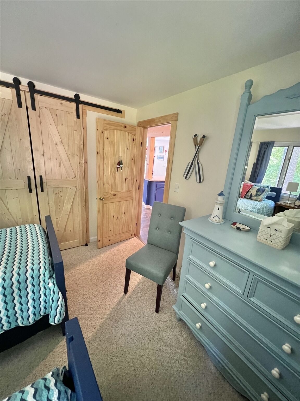 Een slaapkamer met een bed, een kaptafel, een stoel en een kledingkast.
