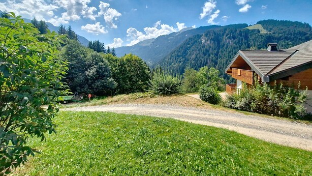 A cabin with a gravel path leading to it, surrounded by lush greenery and mountains in the background. - Corina CN11 QUIET & MOUNTAIN 4 Pers. (Châtel)