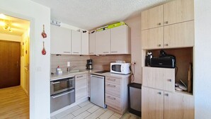 A compact kitchen with a microwave, coffee maker, and a toaster. There are wooden cabinets and a small refrigerator. - Corina CN11 QUIET & MOUNTAIN 4 Pers. (Châtel)
