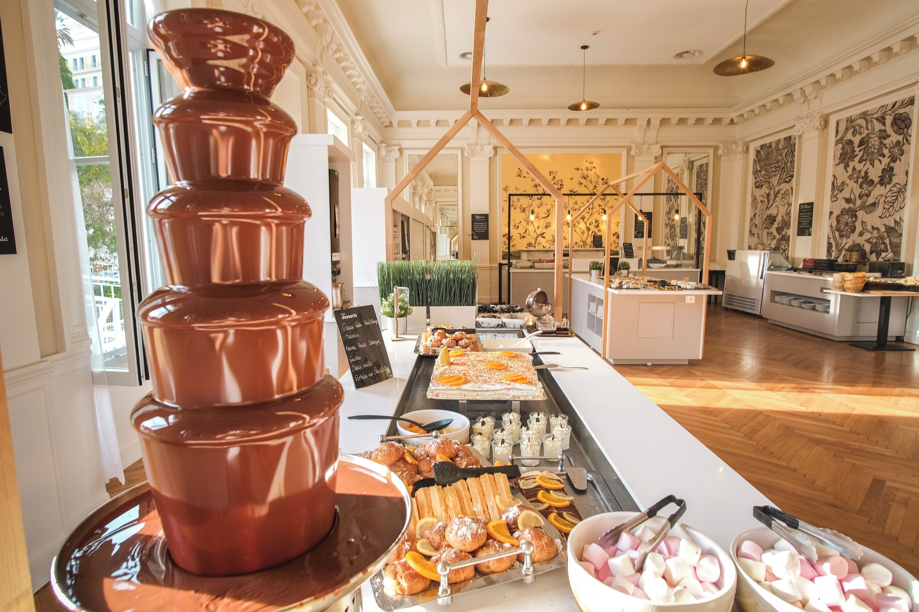 Un buffet proposant une grande variété de plats, notamment des pâtisseries et des desserts, disposés sur une longue table.