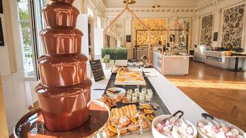 Un buffet proposant une grande variété de plats, notamment des pâtisseries et des desserts, disposés sur une longue table.