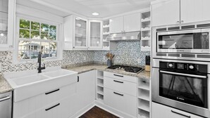 Una cocina moderna con armarios blancos, un horno Bosch y un salpicadero de azulejos.