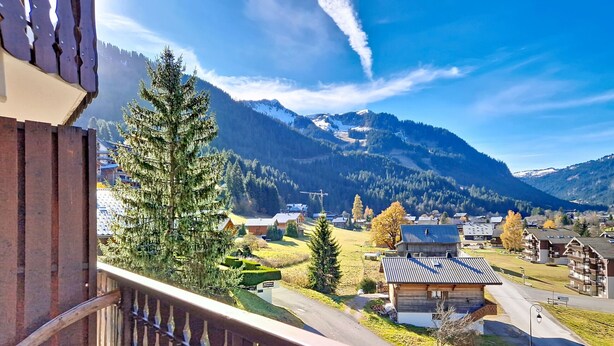 A balcony with a view of a mountain village, including houses and a clear sky. - Forsythia FA18 FAMILY 1& NATURE 4 Pers. (Châtel)