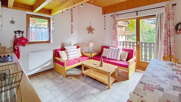 A cozy room with a wooden ceiling, a sofa set, a small table, a window, and a view of greenery outside. - Forsythia FA29 FAMILY 1& NATURE 8 Pers. (Châtel)