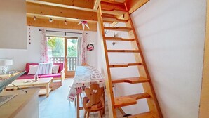 A wooden interior with a dining table, chairs, a sofa, and a wooden ladder. - Forsythia FA29 FAMILY 1& NATURE 8 Pers. (Châtel)