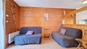 A room with two sofas, a small wooden table, and a shelf with a coffee maker. - Moulin ML154 TELECABINE & MOUNTAIN 3 pers. (Châtel)