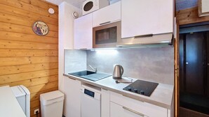Eine kleine Küchenzeile mit Spüle, Wasserkocher und integriertem Mikrowellenherd.