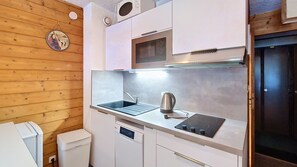 Cucina compatta con lavello, bollitore e forno a microonde integrato.