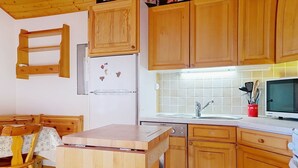 A compact kitchen with wooden cabinets, a built-in refrigerator, a microwave, and a sink. - SORBIERS SS11 VIEW & QUIET 6 Pers. (Châtel)