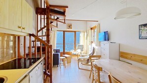 Habitación compacta con cocina, comedor y un pequeño espacio para sentarse.