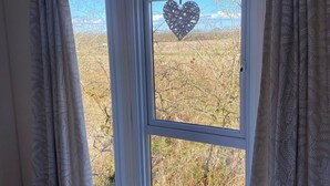 A bedroom with a large window, a bed, and curtains. - Relaxing Lodge In The Heart Of Northumberland (Felton)
