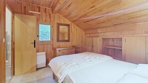 A bedroom with a bed, a dresser, a mirror, and a door.