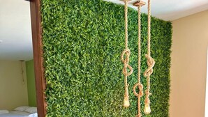 A room with a green wall, a bed, a wooden chair, and a table. - Humaita Pousada (Itacaré)