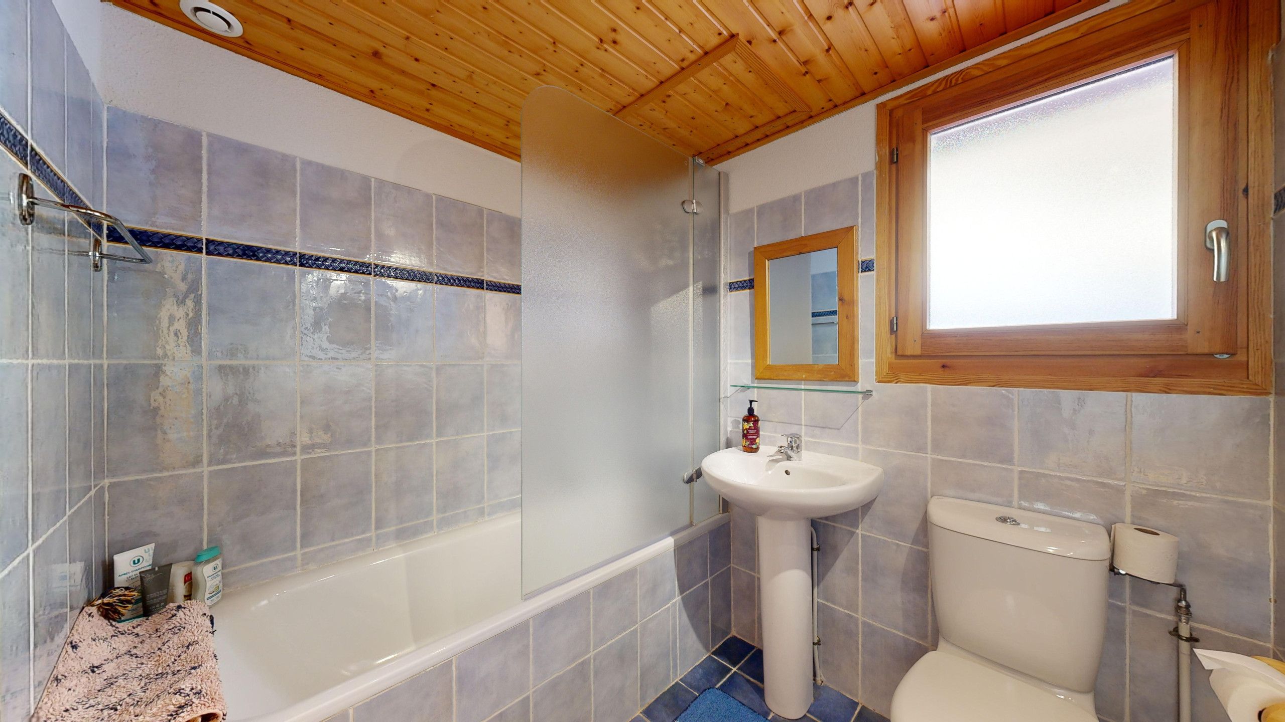 Un baño con bañera, lavamanos e inodoro.