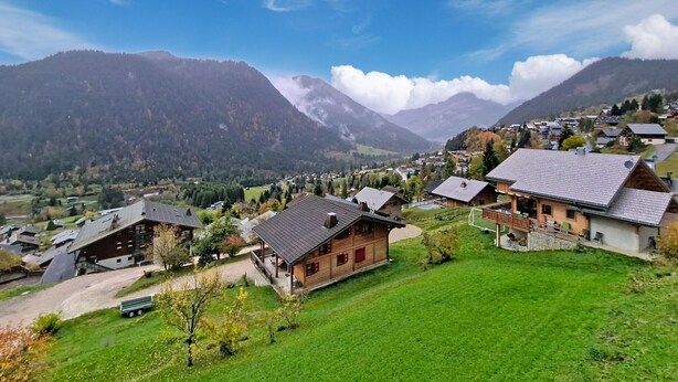 A mountainous village with traditional wooden houses, a clear sky, and a valley below. - Hameau des 4 saisons HSA20  VIEW  & SUN  4 pers. (Châtel)