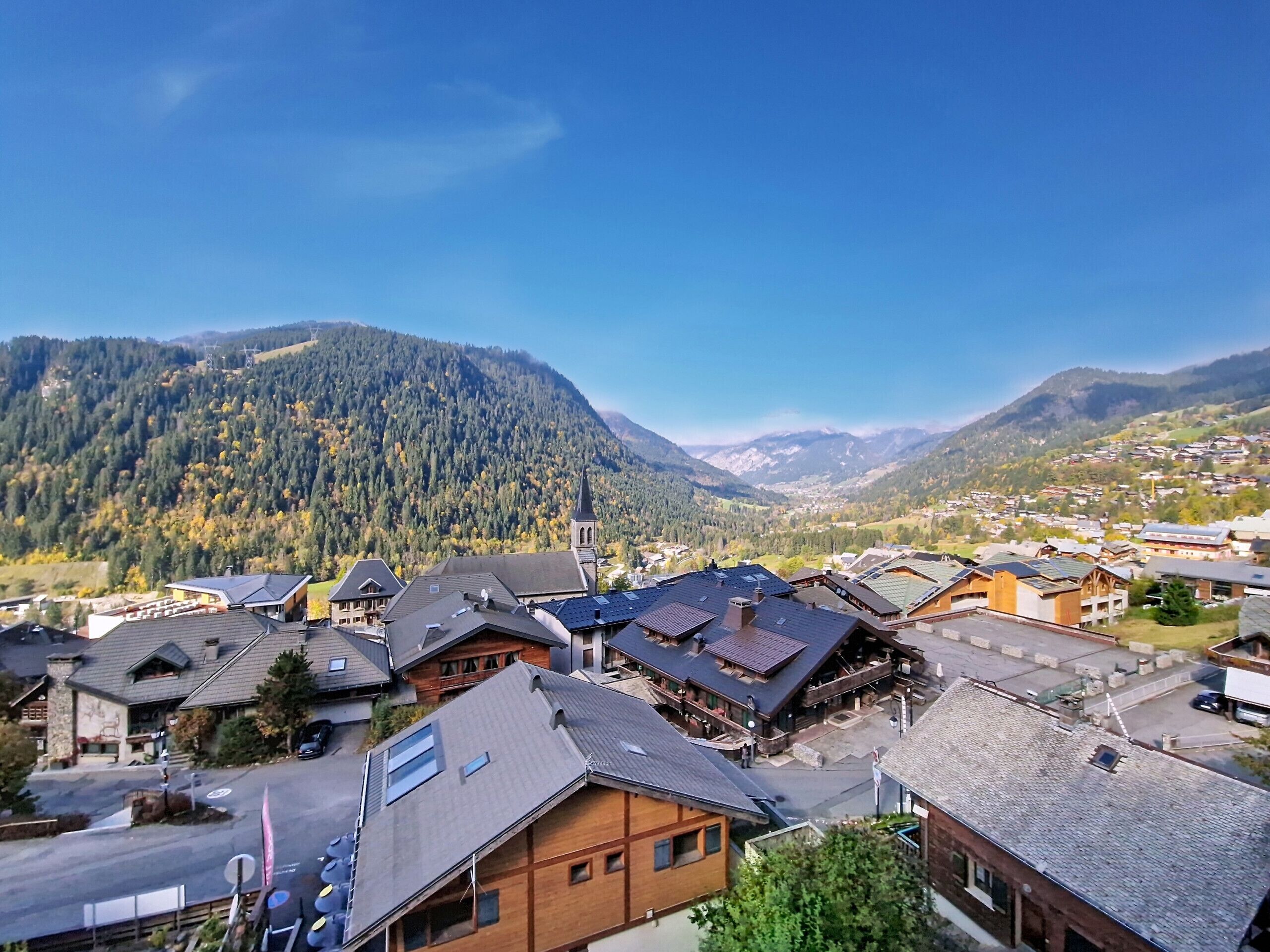 Un villaggio montano con case in legno tradizionali e una chiesa.