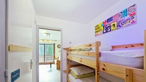 A room with bunk beds, a sign for toilets, and a view of an outdoor area with a table and chairs. - Portes Du Soleil PSB204 TELECABINE & MOUNTAIN 4 pe (Châtel)