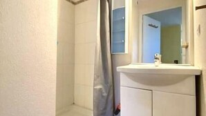Un bagno con doccia, lavandino e specchio.
