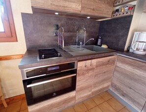Een koelkast, een oven, een koffiezetapparaat/waterkoker, een waterkoker