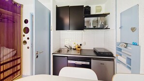 A compact kitchen with a dishwasher, a microwave, and a sink. There is a small countertop with a coffee maker and a cabinet above it. - Campanules CP6 TELECABINE & NATURE 4 Pers (Châtel)