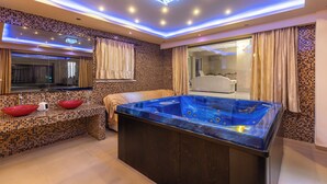 Un baño moderno con una bañera grande, un tocador con dos cuencos rojos y un espejo sobre el tocador.