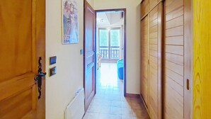 A hallway with wooden doors, a radiator, and a poster on the wall. - Biches BIB31 MOUNTAIN & QUIET 4 Pers. (Châtel)