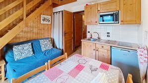 A compact kitchen with wooden cabinets, a microwave, and a sink. - Biches BIB31 MOUNTAIN & QUIET 4 Pers. (Châtel)