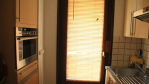 A kitchen with a built-in oven, a microwave, and a sink.