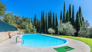 A swimming pool with a stone deck, surrounded by trees and a stone wall. - Al Vittoriale 3 by Wonderful Italy (Gardone Riviera)