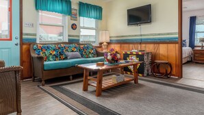 Una sala de estar acogedora con sofá, mesa de centro y televisor.