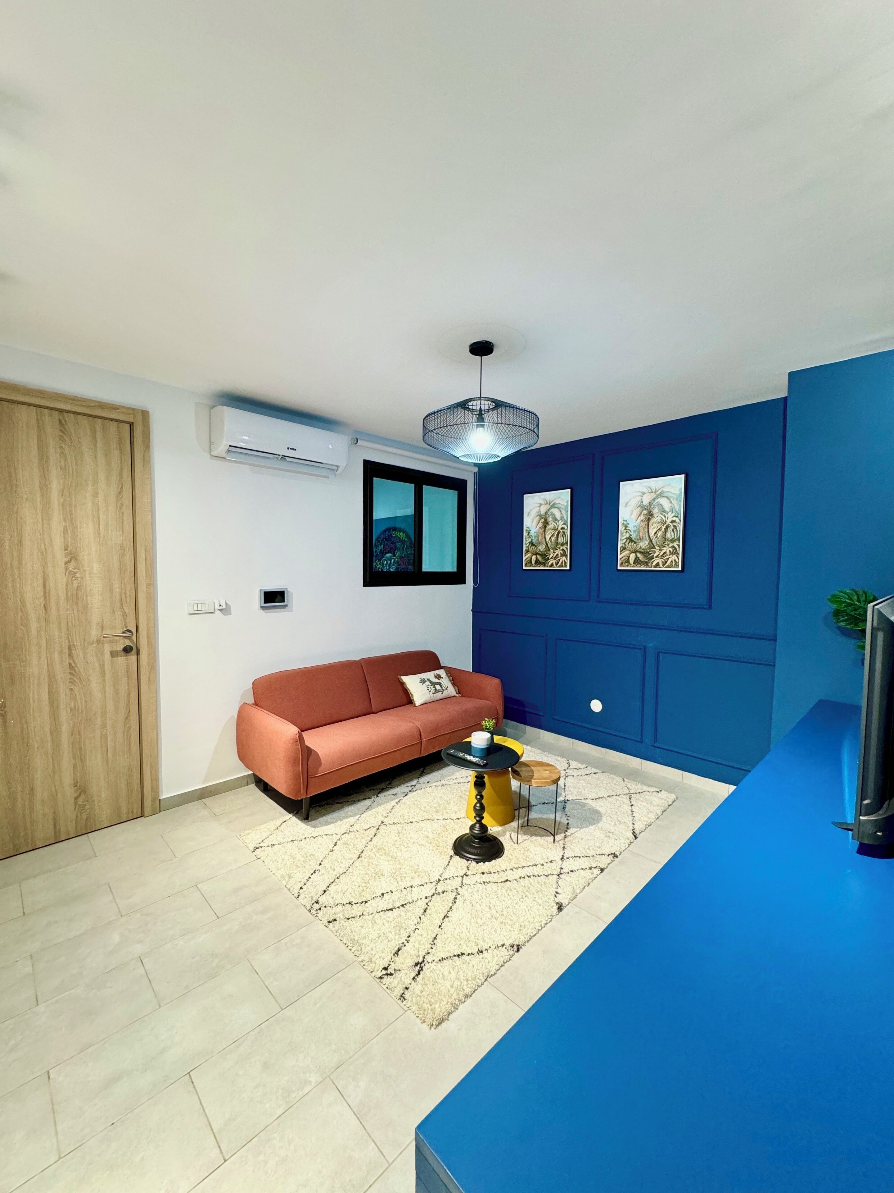 Un salon moderne avec un canapé, une table basse et un mur d’accent bleu.