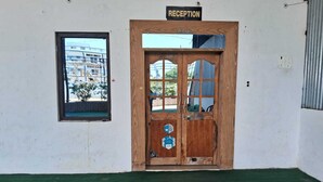 A reception area with a wooden door, a small window, and a sign above the door.