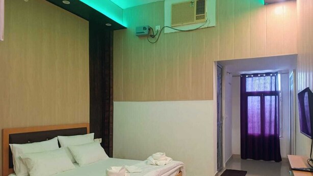 A hotel room with a bed, a desk, and a television.