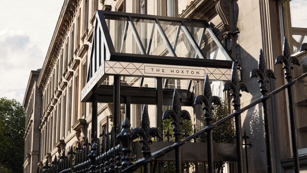 Fachada de un edificio con un letrero que dice THE HOXTON.
