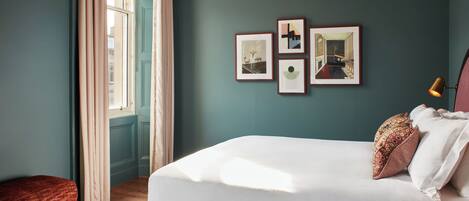 Una camera da letto ordinata con un letto, un comodino e una finestra con tende.