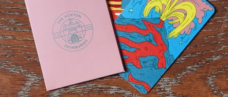 Three colorful cards with illustrations on a wooden surface.