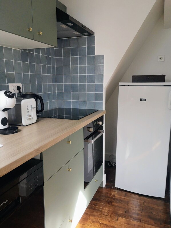 A compact kitchen with a wooden countertop, a built-in oven, a white refrigerator, and a toaster. - Superb apartment - heart of old town - Cathedral view (Vannes)